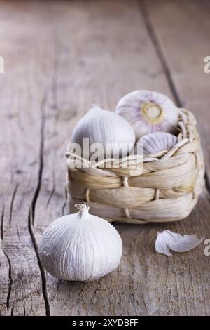 Chinesische solo Knoblauch in einem kleinen Weidenkorb auf hölzernen Hintergrund. Selektiven Fokus Stockfoto