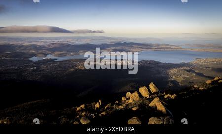 Blick vom Mount Wellington auf die Stadt Hobart, Tasmanien, Australien mit Felsen im Nachmittagslicht Stockfoto