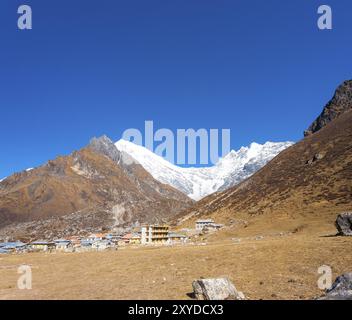Majestätische Aussicht auf schneebedeckte Langtang Lirung Himalaya-Gebirge mit Kyanjin Gompa Dorf im Vordergrund in Nepal. Vor 2015 Gorkha Erdbeben Stockfoto