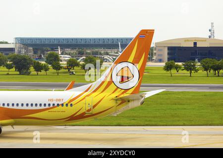 Bangkok, Thailand, 3. November 2015: Golfplatz und Golfspieler im Wagen sichtbar hinter dem Heckteil und Logo des Billigflugzeugs NOK Air ta Stockfoto