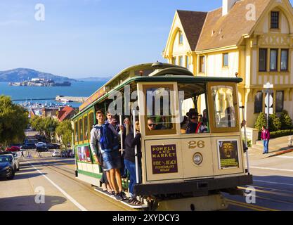 San Francisco, USA, 12. Mai 2016: Nahaufnahme der sich nähernden Seilbahn der Hyde Street, voll von Menschen, die auf der Außenplattform stehen und eine steile Bergfahrt genießen Stockfoto