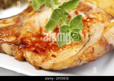 Majoran auf einem gegrillten Schweinesteak Stockfoto