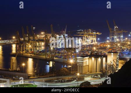 Hafen von Barcelona in der Nacht vom Mittelmeer in Spanien, industrielle Landschaft mit Krane, Container, import und export Cargo Fracht Stockfoto