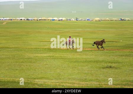 Ulaanbaatar, Mongolei, 12. Juni 2007: Junger Junge zu Pferd, der das Rudel beim Pferderennwettbewerb des Naadam Festivals in Asien anführt Stockfoto