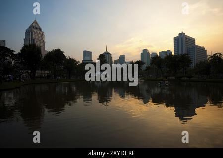 Die Skyline der Innenstadt von Bangkok spiegelt sich wunderschön im See im Lumphini Park wider Stockfoto