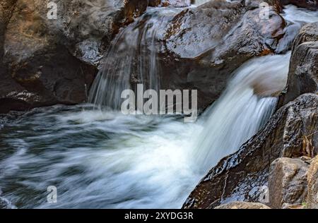 Kleiner Bach mit klarem Wasser und Kaskade, der durch die Felsen der Berge von Minas Gerais, Brasilien, Südamerika verläuft Stockfoto