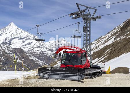 Zermatt, Schweiz, 12. April 2017: Eine rote Schneeräummaschine parkt neben einem Skilift, Europa Stockfoto