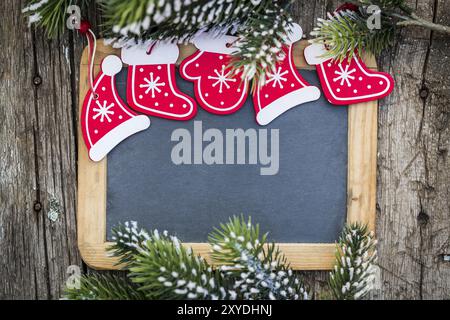 Tafelschachtel, eingerahmt in wunderschönen Weihnachtsbaumzweigen und Dekorationen. Konzept für Winterferien. Kopieren Sie den Platz für Ihren Text Stockfoto