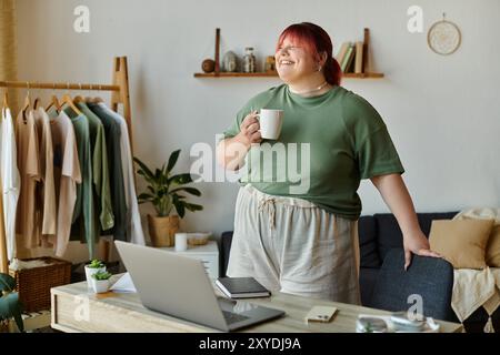 Eine Frau lächelt hell, während sie eine Tasse Kaffee zu Hause genießt. Stockfoto