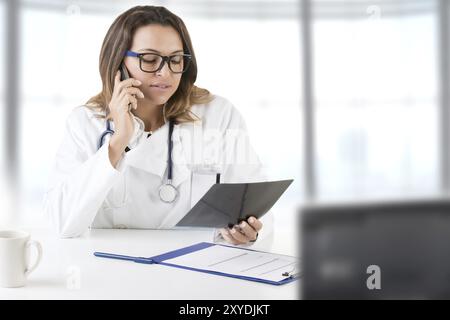 Ärztin bei der Arbeit betrachten eine Röntgenaufnahme Stockfoto