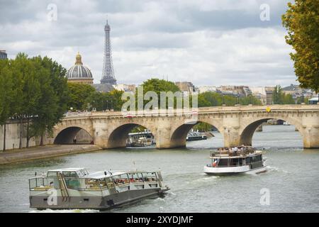 Ein wunderschönes Stadtbild einschließlich des Eiffelturms in der Ferne mit Kreuzfahrtschiffen, die die pont neuf auf der seine in Paris, Frankreich, Europa passieren Stockfoto