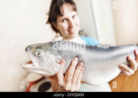 Gesunde Ernährung Meeresfrüchte, Schönheit junge lächelnde Frau Hand hält rohen Lachs oder Forelle Fisch Essen in der Küche Stockfoto