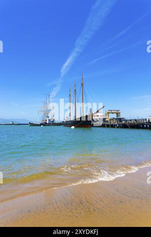Weitwinkelaufnahme des Strandvordergrundes neben der Touristenattraktion Hyde Street Pier mit Schiffen an Fisherman's Wharf an einem Sommertag in San Francisco, Stockfoto