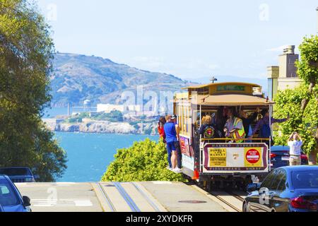 San Francisco, USA, 15. Mai 2016: Seilbahn mit Touristen, die vor dem Hotel fahren, nähern sich dem steilen Abgrund auf dem Gipfel der Hyde St mit einem fantastischen Blick auf ALCA Stockfoto