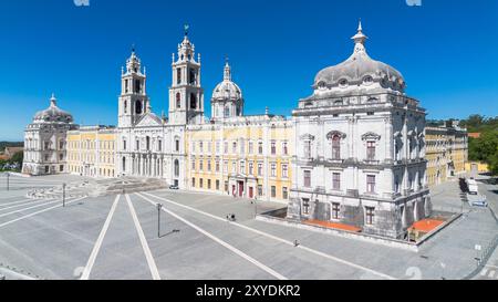 Palácio Nacional de Mafra [Fassade der Basilika, des königlichen Palastes, der Bibliothek und des ehemaligen Klosters in Mafra, Portugal, an einem sonnigen Tag] Stockfoto