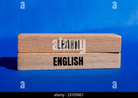 Lernen Sie englische Botschaft auf Holzblöcken mit blauem Hintergrund. Symbol für konzeptuelles Lernen englisch. Kopierbereich. Stockfoto
