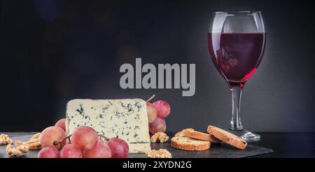 Ein Panorama von Gorgonzola mit Rotwein auf einem dunklen Hintergrund mit Kopie Raum Stockfoto