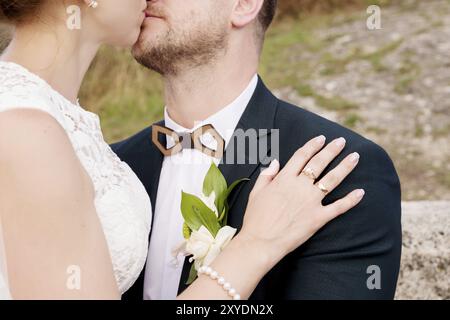 Nahaufnahme der Hände in Umarmungen von Jungvermählten am Hochzeitstag. Das Konzept von Hochzeitsglück und Zärtlichkeit Stockfoto