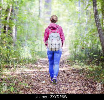 Junge Frau geht im Frühling durch den Wald Stockfoto
