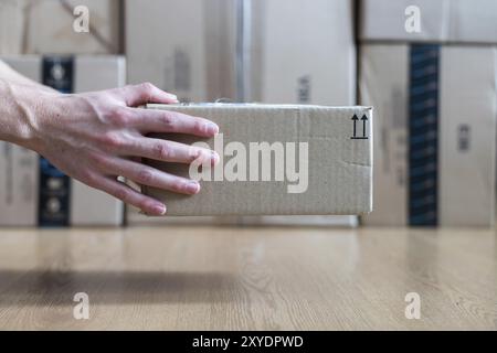 Karton Versand Konzept: der Mensch ist mit einem braunen Paket Stockfoto