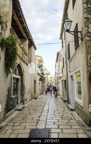 Kroatien, 28 08 2014: Blick auf eine enge Straße auf der Insel mit Touristen zu Fuß und kleinen Souvenirläden und Restaurants, Touristenattraktion, Euro Stockfoto