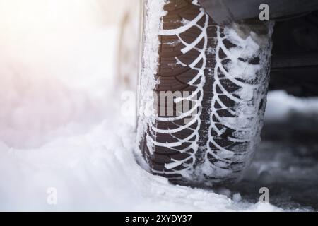 Nahaufnahme von Autoreifen bedeckt mit Schnee auf rutschiger Fahrbahn Stockfoto