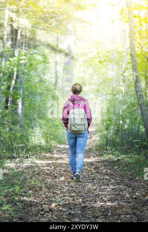 Junge Frau geht im Frühling durch den Wald Stockfoto