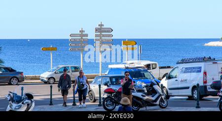 Ajaccio, Korsika - 11. Oktober 2019: Touristen mit Wegweisern am malerischen Parkplatz an der Küste. Stockfoto