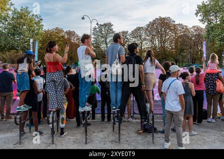 Paris, Frankreich. August 2024. Die Zuschauer der Eröffnungszeremonie der Paralympischen Spiele 2024 in Paris auf der Avenue des Champs-Elysées blicken über einen Zaun, um die vorbeifahrenden Athleten zu sehen. Quelle: Fabienne Koch/Alamy Live News Stockfoto