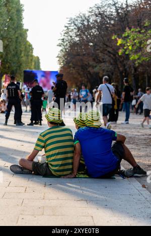 Paris, Frankreich. August 2024. Drei brasilianische Fans warten auf die Eröffnungszeremonie der Paralympischen Spiele 2024 in Paris auf der Avenue des Champs-Elysées. Quelle: Fabienne Koch/Alamy Live News Stockfoto