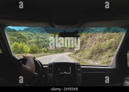 Blick aus dem Fahrerhaus auf den Transport auf die BergSerpentinen und Wälder in der Schlucht, an der die Straße vorbeiführt Stockfoto