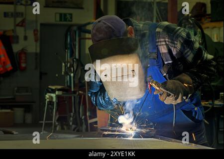 Schweißer in seiner Werkstatt beim Elektroschweißen Stockfoto