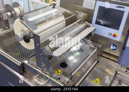 Rolle Kunststoffverpackungsfolie auf der automatischen Verpackungsmaschine in der Lebensmittelfabrik Industrie Stockfoto