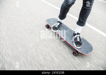 Nahaufnahme eines Longboarders mit schnellen Füßen auf einem Longboard auf Asphalt Stockfoto