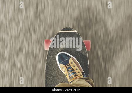 Detail Skateboard teilweise groß mit den Beinen eines Mannes in Sneakers Stockfoto