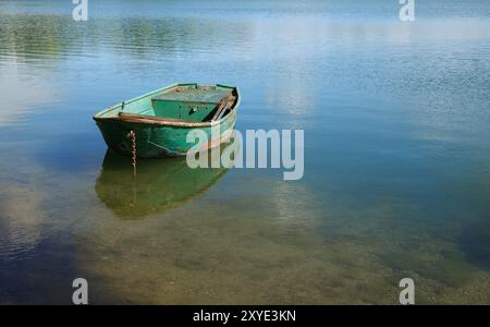 Ruderboot auf einem ruhigen See mit Reflexion Stockfoto