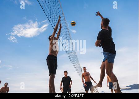 Teams mit multinationalen Spielern spielen im Sommer Beachvolleyball am Strand in Vietnam. Nha Trang, Vietnam - 4. August 2024 Stockfoto