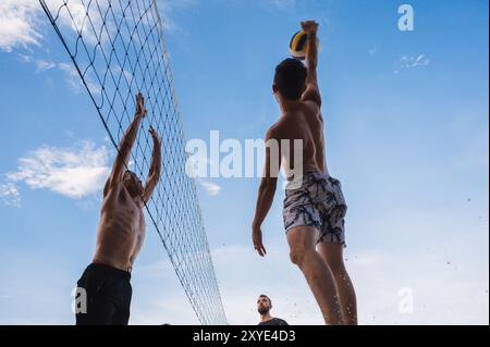 Teams mit multinationalen Spielern spielen im Sommer Beachvolleyball am Strand in Vietnam. Nha Trang, Vietnam - 4. August 2024 Stockfoto