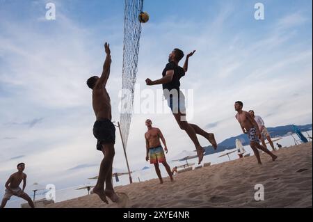 Teams mit multinationalen Spielern spielen im Sommer Beachvolleyball am Strand am Meer in Vietnam. Nha Trang, Vietnam - 4. August 2024 Stockfoto
