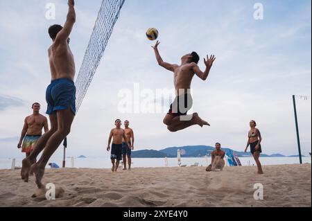 Im Sommer spielen multinationale Spieler Beachvolleyball am Meer in Nha Trang in Asien. Nha Trang, Vietnam - 4. August 2024 Stockfoto