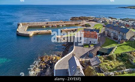 Portsoy Aberdeenshire Schottland im Sommer die äußeren Hafenmauern und Häuser und ein blaues Meer im Moray Firth Stockfoto