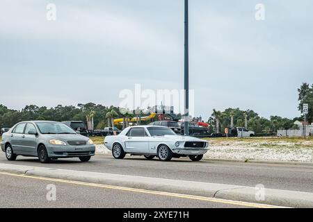 Gulfport, MS - 05. Oktober 2023: Weitwinkel-Eckansicht eines Toyota Corolla LE Sedan aus dem Jahr 2004 und eines Ford Mustang Hardtop Coupés aus dem Jahr 1968 auf einer lokalen Autoshow. Stockfoto