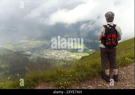 Frau, die von einem Wanderweg ins Tal schaut Stockfoto