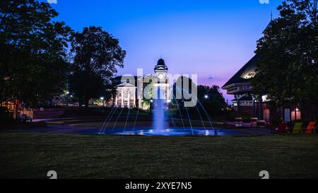 Ein beleuchteter Blick auf das Rathaus in der Stadt Duluth in Georgia, aufgenommen bei Sonnenuntergang mit einem Brunnen im Vordergrund Stockfoto