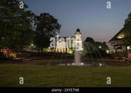 Ein beleuchteter Blick auf das Rathaus in der Stadt Duluth in Georgia, aufgenommen bei Sonnenuntergang mit einem Brunnen im Vordergrund Stockfoto