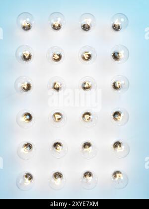 Array von beleuchteten Glühlampen Wolfram Glühbirnen auf blauem Hintergrund Stockfoto