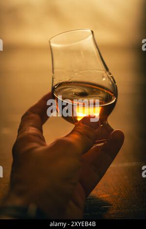 Farb-Nahaufnahme einer Hand, die ein einzelnes Glencairn Whiskyglas hält. Stockfoto
