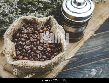 Kaffeebohnen, Beutel und Becher mit Kaffeebohnen. Moderner Vintage-Stil Stockfoto