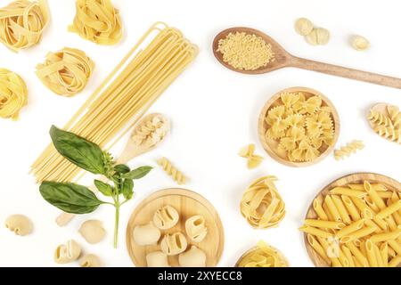 Ein Foto von verschiedenen Arten von Nudeln, wie Spaghetti, Penne, Fusilli und andere, mit frischem Basilikum, bilden einen Rahmen, geschossen von ab Stockfoto