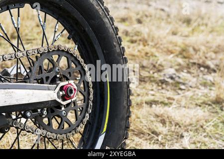 Motorrad-Trial und Enduro am Hinterrad. Montiert auf Radgetriebe und Kette mit Speichen. Nahaufnahme des Hinterrads eines Geländemotorrads Stockfoto